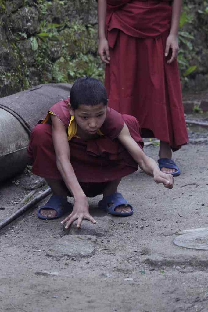 Niños jugando a las canicas.